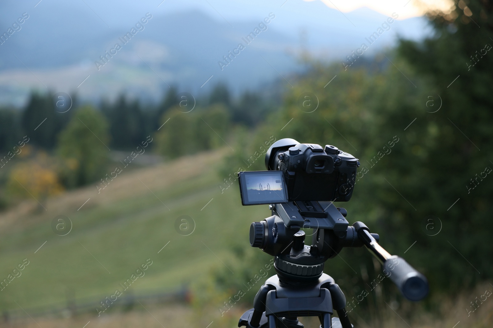 Photo of Taking photo of beautiful mountain landscape with camera mounted on tripod outdoors, space for text