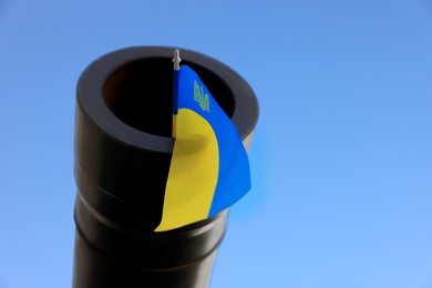 Photo of Ukrainian flag in muzzle of tank outdoors