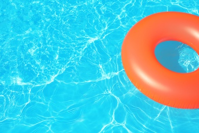 Inflatable ring floating in swimming pool on sunny day. Space for text