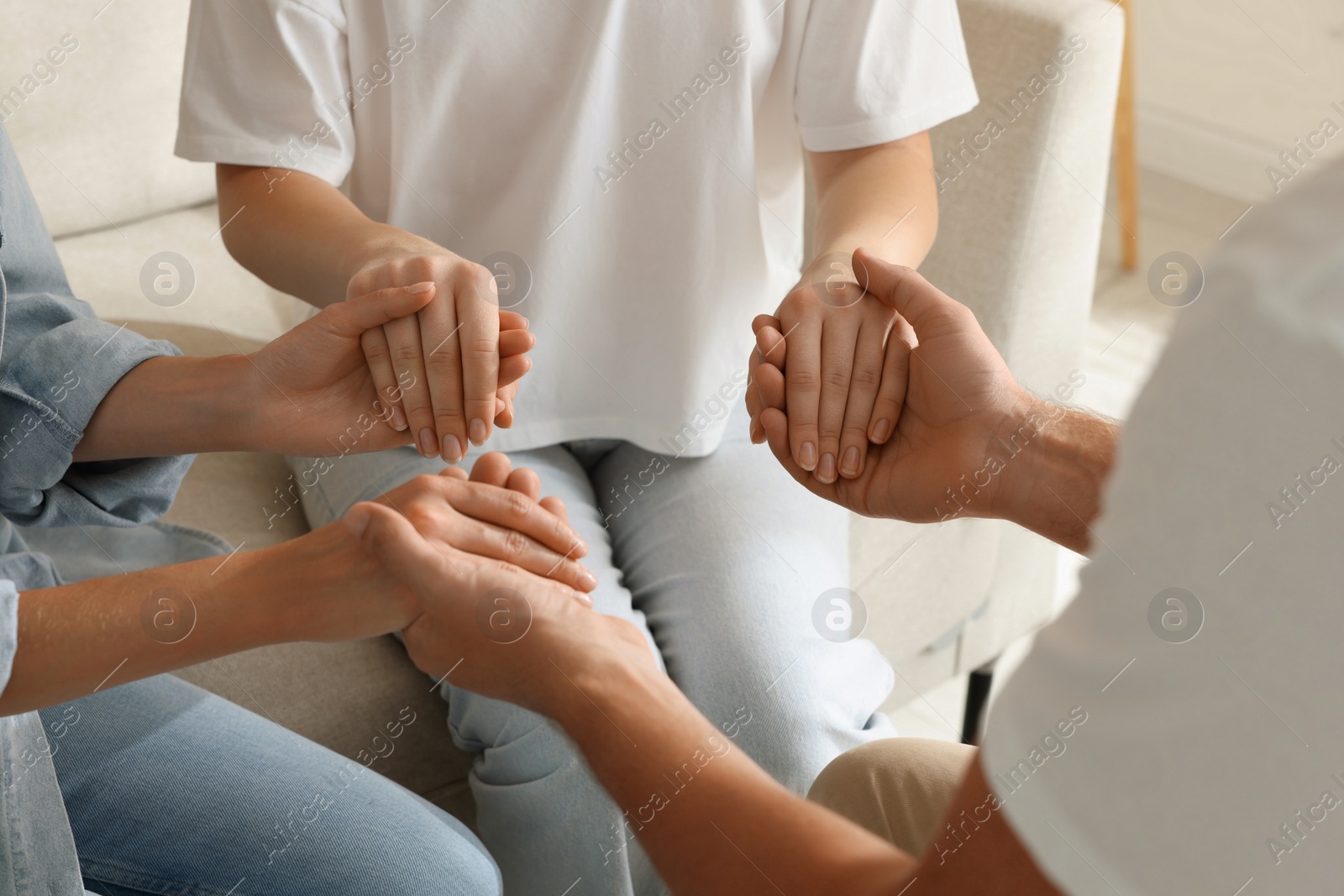 Photo of Group of religious people holding hands and praying together indoors, closeup