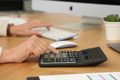 Photo of Accountant working at wooden desk in office, closeup