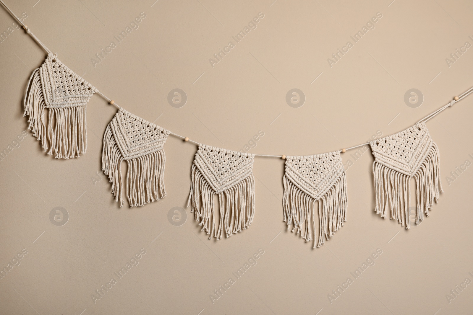 Photo of Stylish large macrame hanging on beige wall