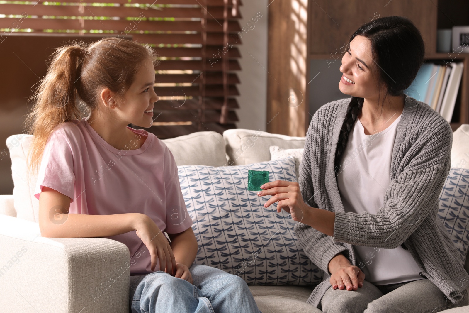 Photo of Mother talking with her teenage daughter about contraception at home. Sex education concept