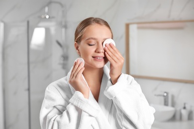 Beautiful young woman with cotton pads indoors