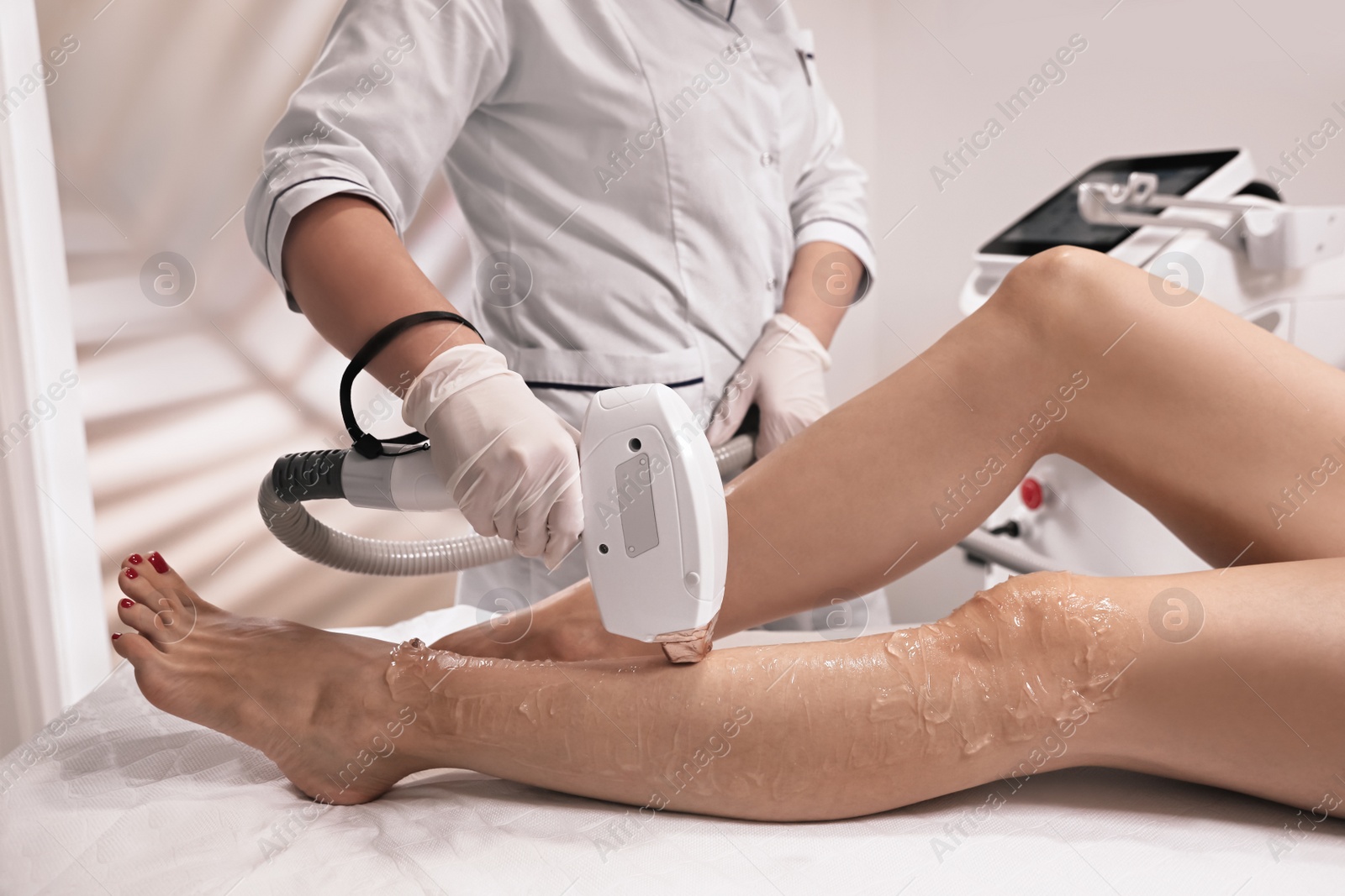 Photo of Woman undergoing laser epilation procedure in beauty salon, closeup