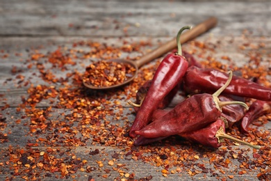 Dry chili peppers and powder on wooden background