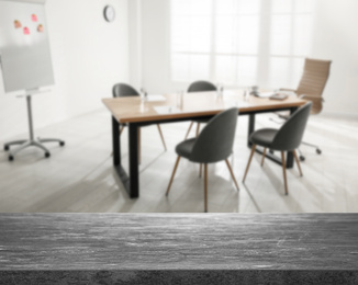 Empty stone surface and blurred view of modern office interior, closeup. Space for text 