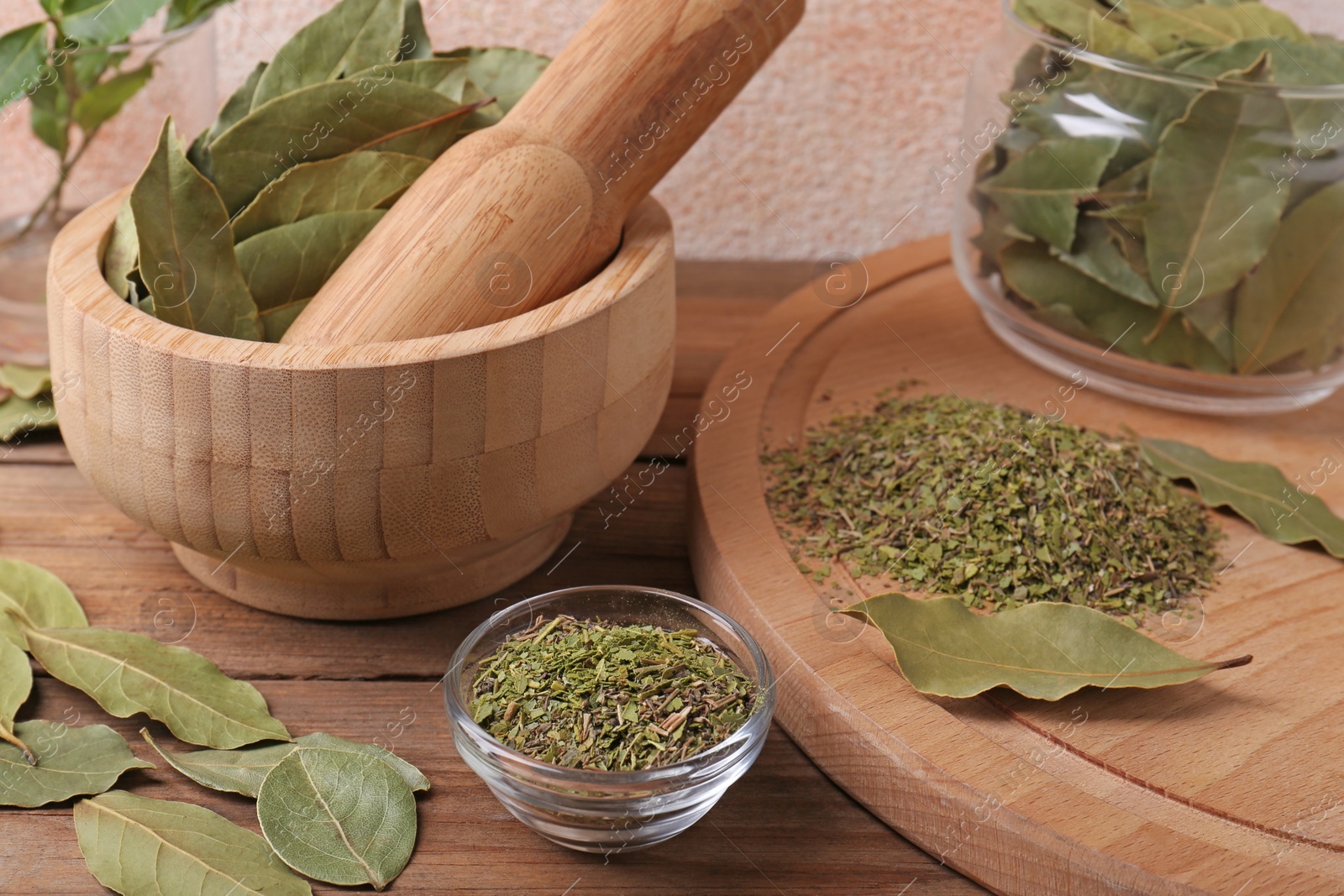 Photo of Whole and ground aromatic bay leaves on wooden table