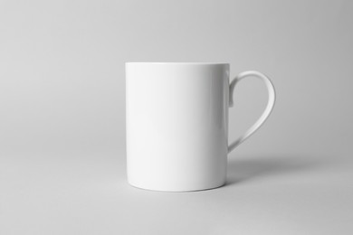 Photo of White ceramic mug on light grey background