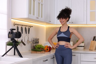 Smiling food blogger recording video in kitchen