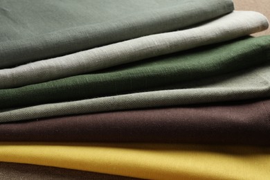 Photo of Many different fabrics on brown cloth, closeup