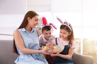 Photo of Cute family with Easter eggs at home