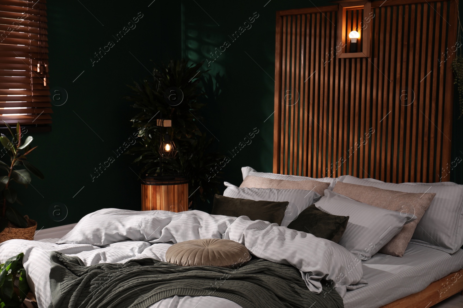 Photo of Stylish interior with large comfortable bed and potted plants