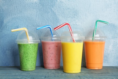 Plastic cups with delicious detox smoothies on table