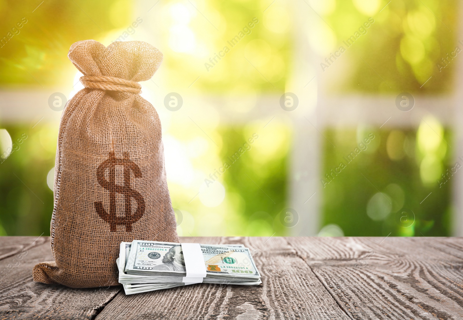 Image of Burlap bag with dollar sign and banknotes on wooden table indoors. Space for text