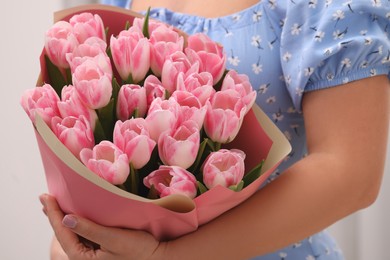 Photo of Woman with bouquet of beautiful fresh tulips on white background, closeup