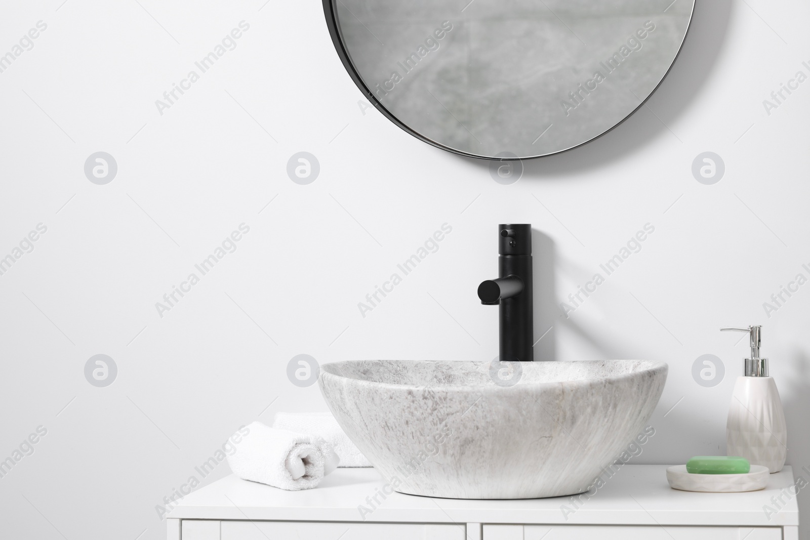 Photo of Different bath accessories and personal care products near sink on bathroom vanity