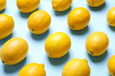 Photo of Many fresh ripe lemons on light blue background