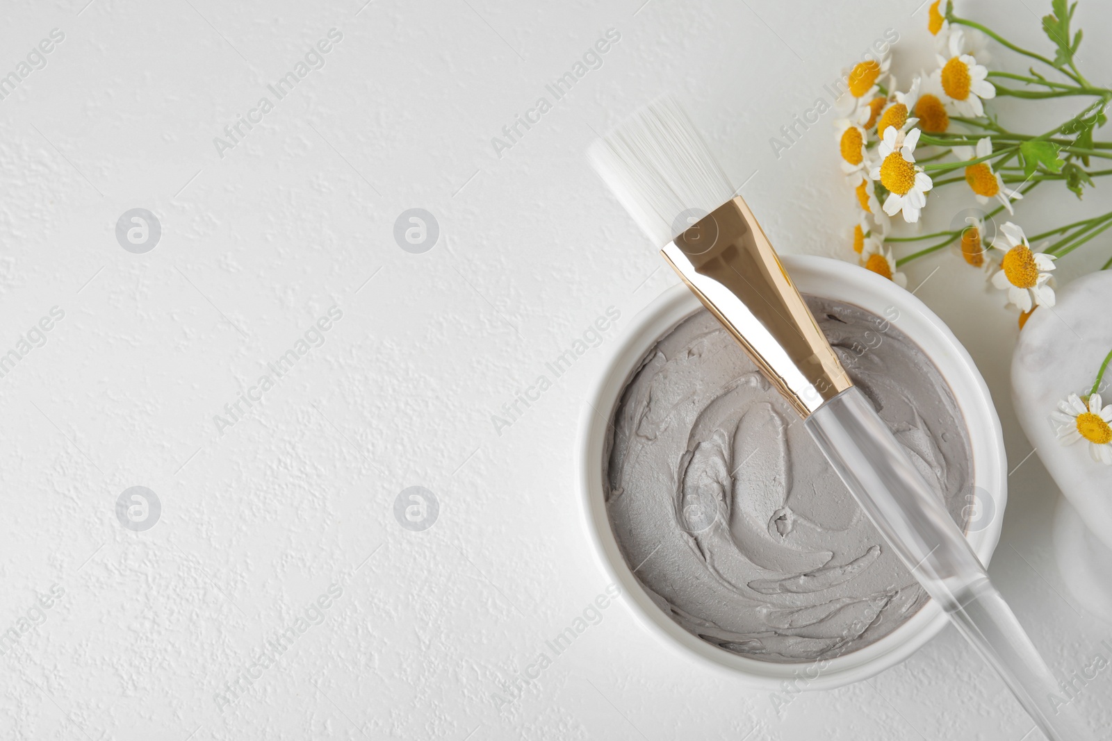 Photo of Professional face mask with flowers on white table, flat lay. Space for text
