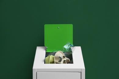 Overfilled trash bin on color background. Recycling concept