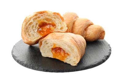 Slate plate with tasty croissants on white background