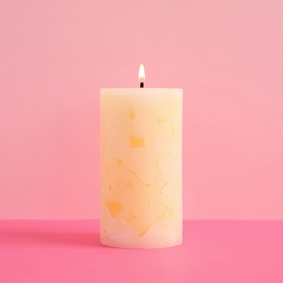 Alight scented wax candle on color background