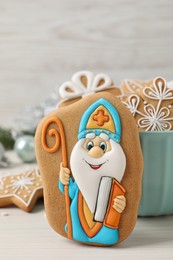 Photo of Tasty gingerbread cookies on white wooden table. St. Nicholas Day celebration