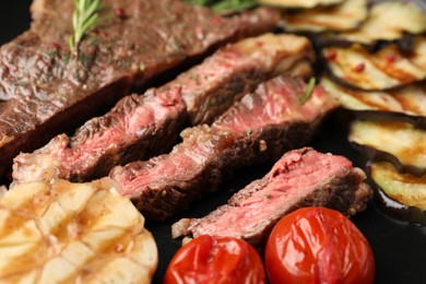 Photo of Delicious grilled beef steak with vegetables and spices, closeup