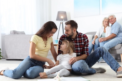 Photo of Young couple spending time with their daughter at home. Happy family