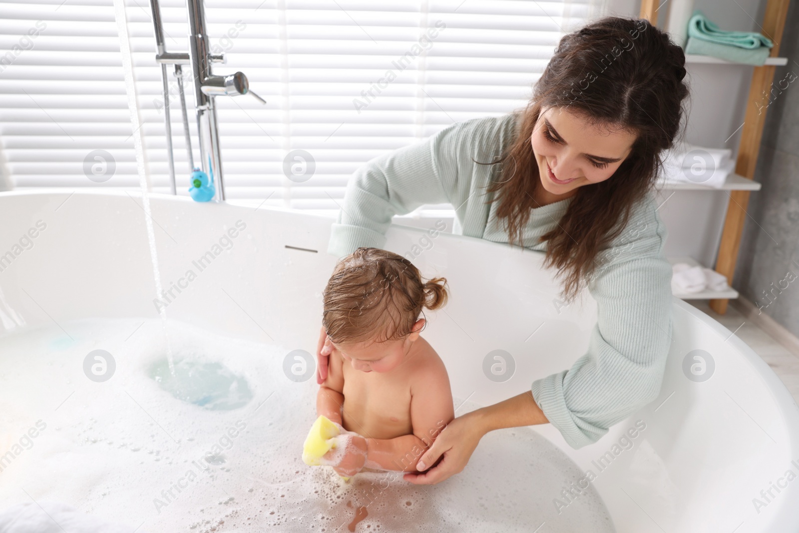 Photo of Mother with her little daughter in bathroom