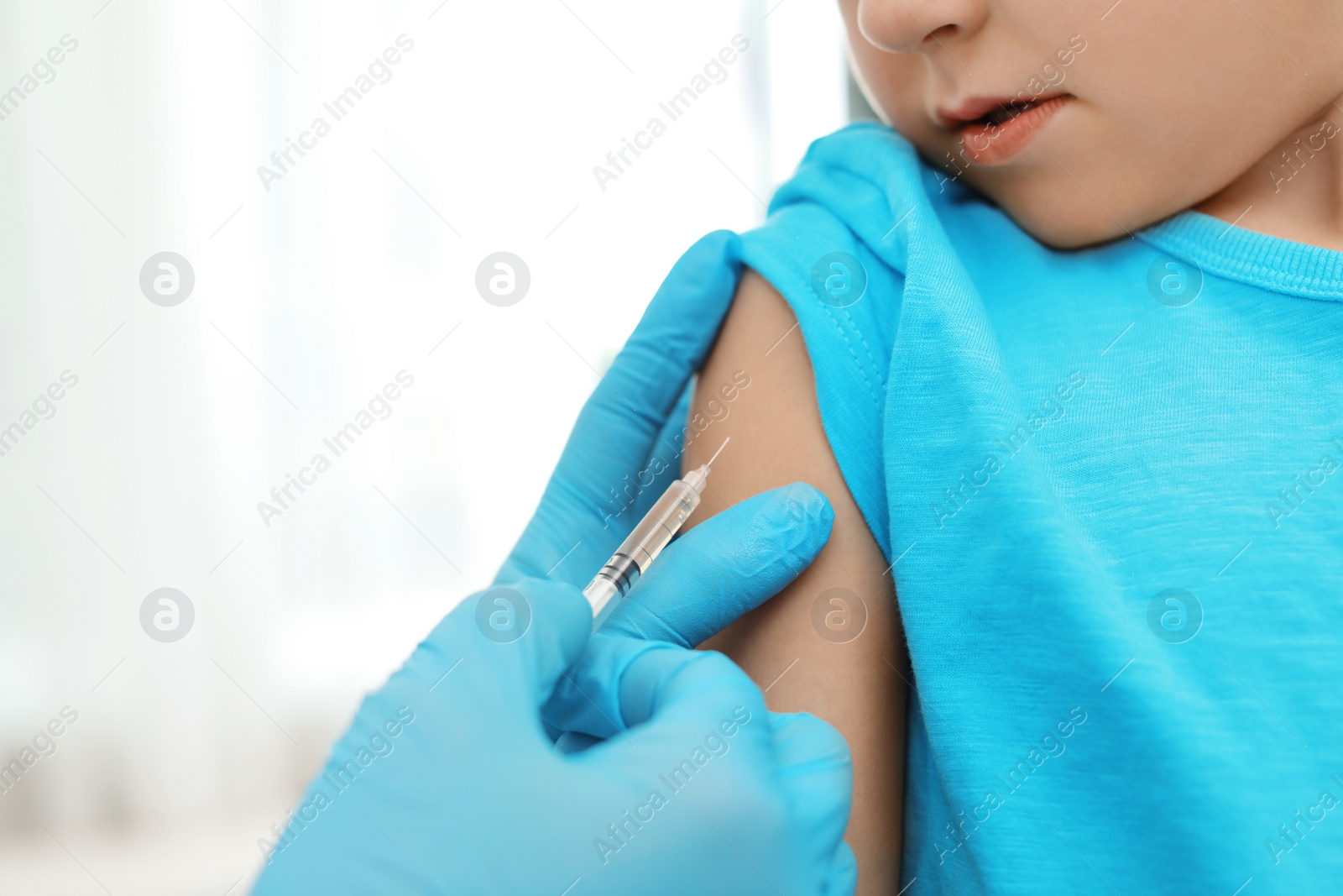 Photo of Children's doctor vaccinating little boy, closeup. Space for text