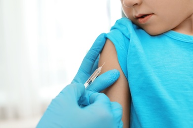 Photo of Children's doctor vaccinating little boy, closeup. Space for text
