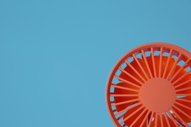Photo of Modern electric fan on light blue background. Space for text