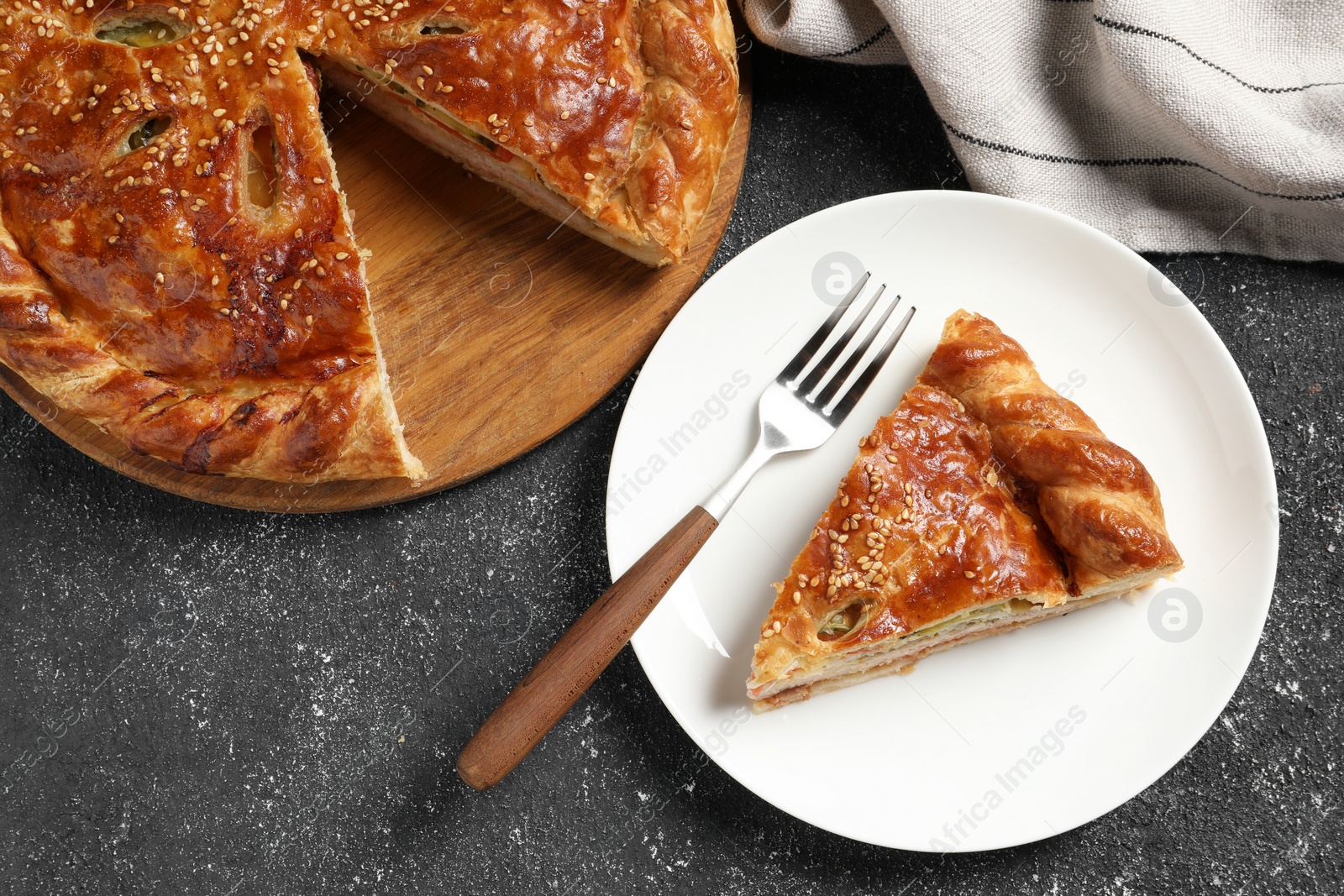 Photo of Tasty homemade pie with filling served on black table, flat lay