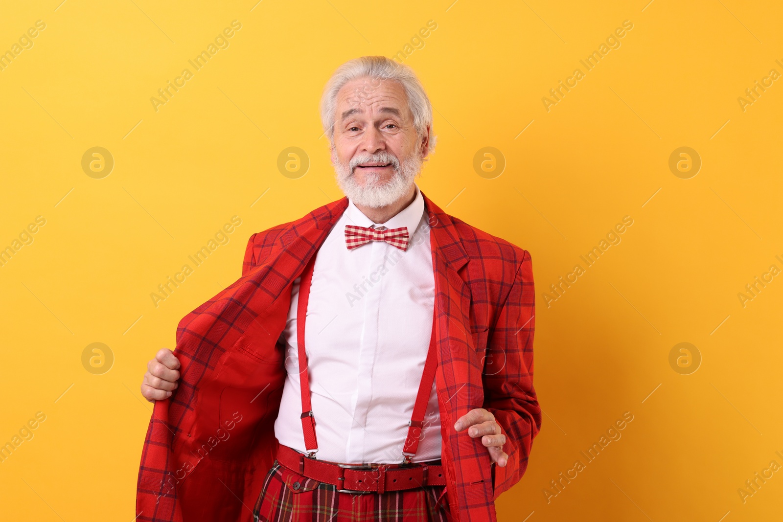 Photo of Portrait of grandpa with stylish red suit and bowtie on yellow background