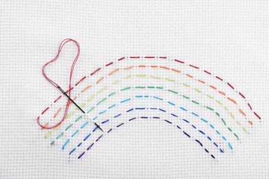 Photo of Canvas with embroidered rainbow and needle, top view