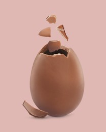 Image of Exploded milk chocolate egg on dusty pink background