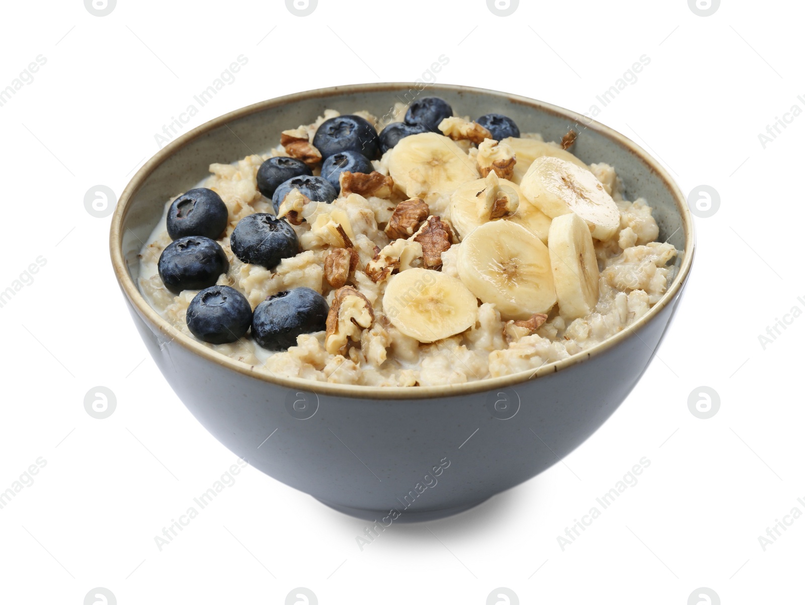 Photo of Tasty oatmeal with banana, blueberries, milk and walnuts in bowl isolated on white
