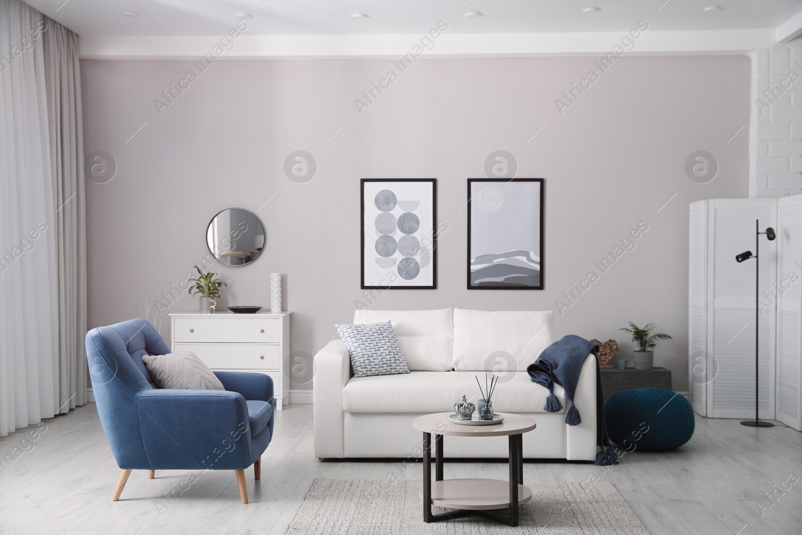 Photo of Stylish living room interior with white sofa, armchair and small coffee table