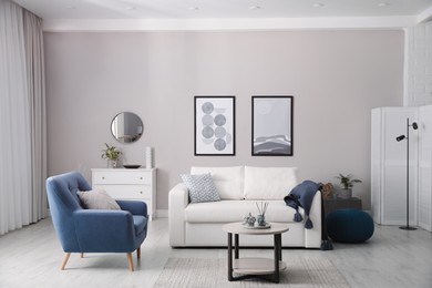 Photo of Stylish living room interior with white sofa, armchair and small coffee table