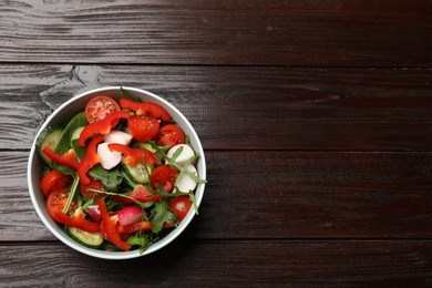 Photo of Tasty fresh vegetarian salad on dark wooden table, top view. Space for text