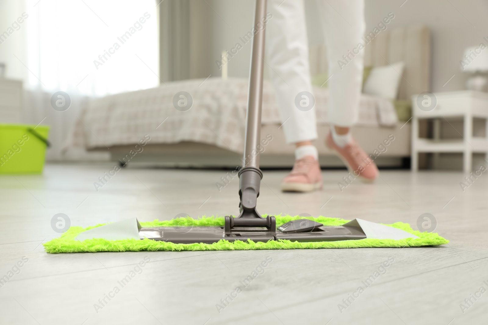 Photo of Woman cleaning floor with mop at home, closeup