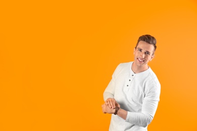 Photo of Handsome young man smiling on color background