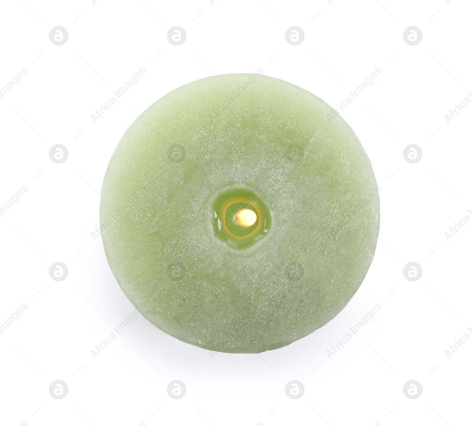 Photo of Burning green wax candle isolated on white, top view