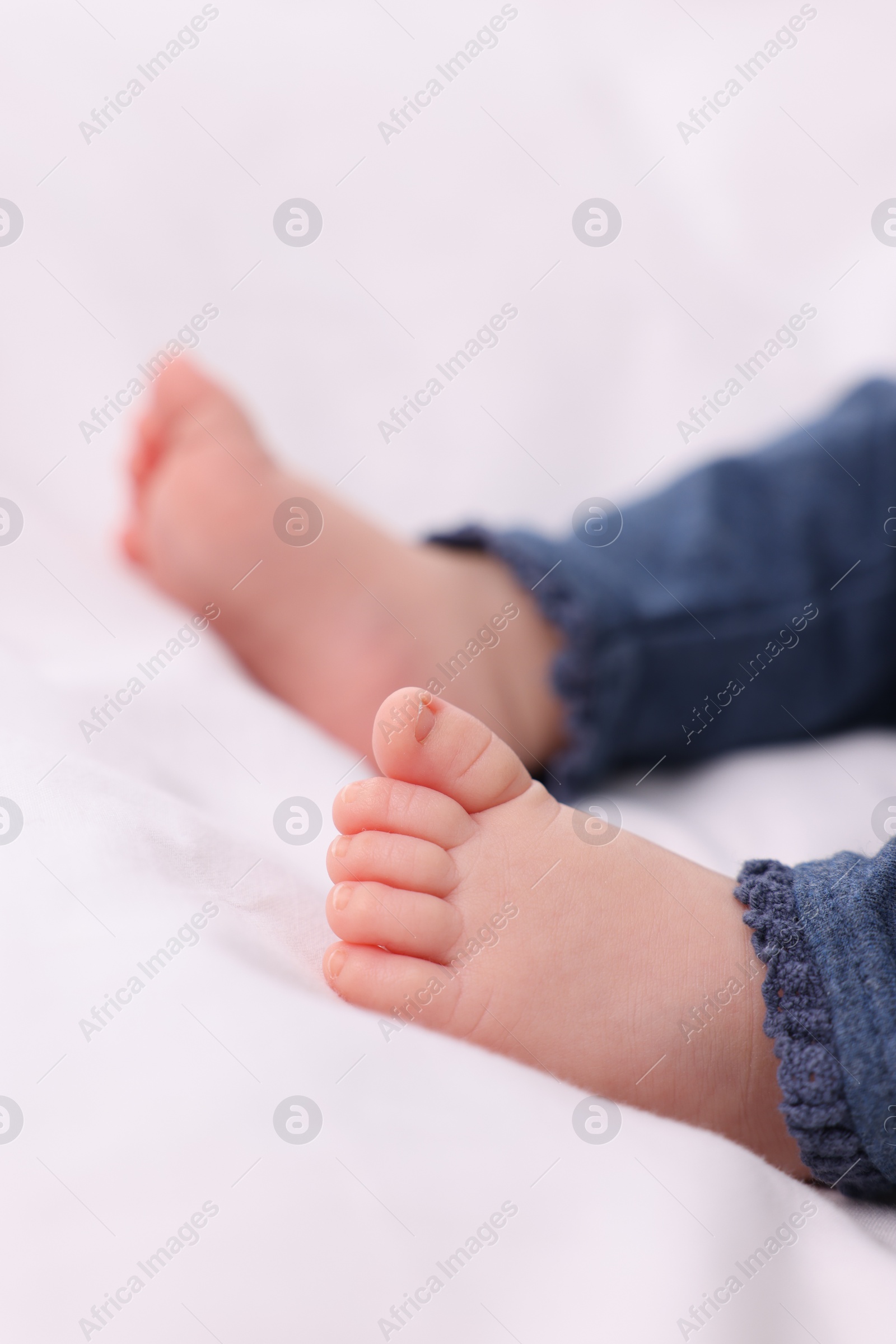 Photo of Newborn baby lying on white blanket, closeup