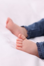 Photo of Newborn baby lying on white blanket, closeup