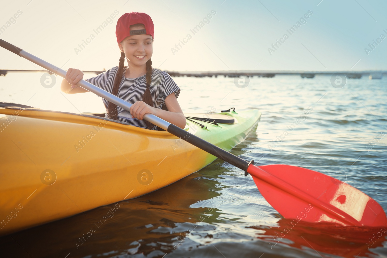 Photo of Happy little girl kayaking on river. Summer camp activity