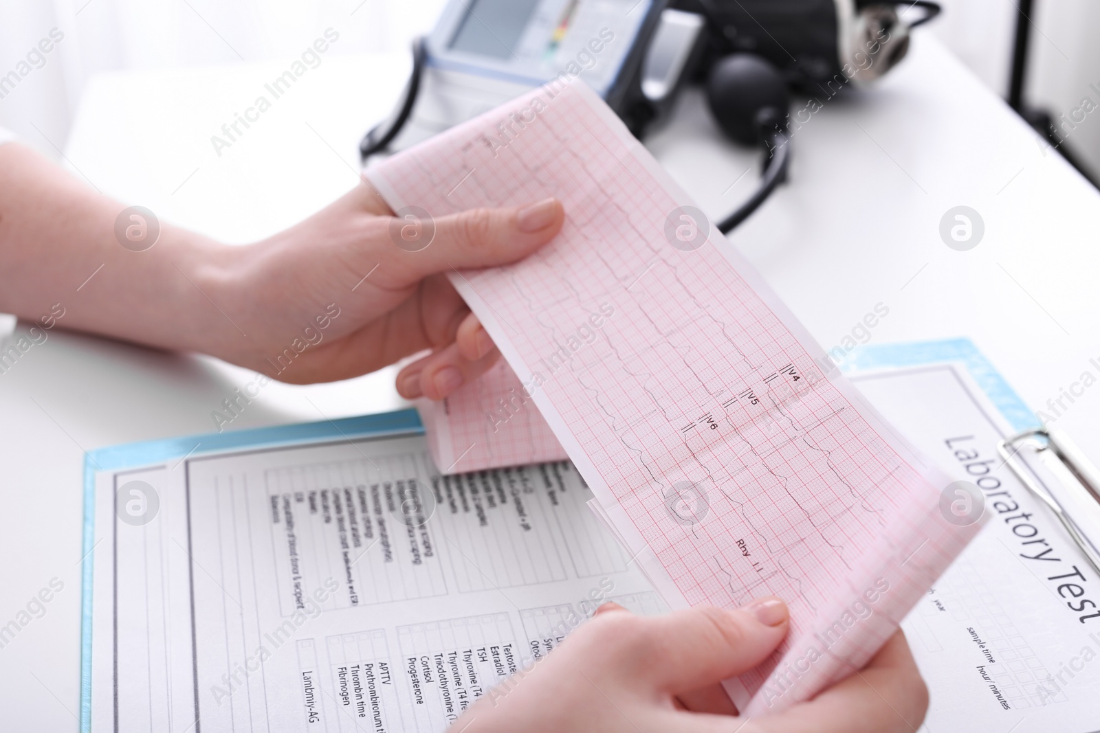 Photo of Doctor examining cardiogram at table in clinic, closeup