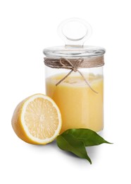 Photo of Delicious lemon curd in glass jar, fresh citrus fruit and green leaves isolated on white