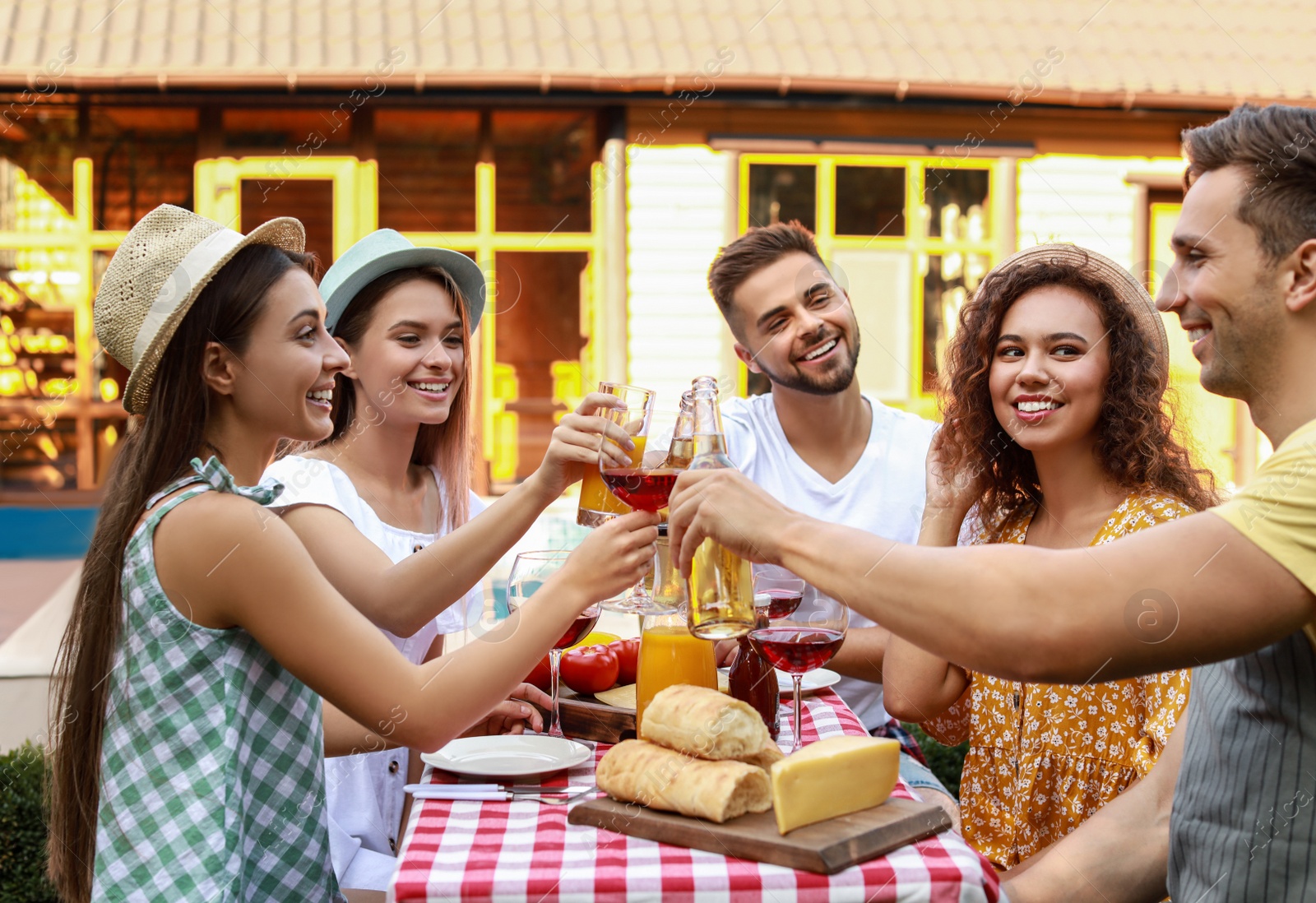 Photo of Happy friends with drinks having fun at barbecue party outdoors